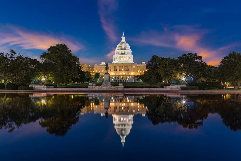 The U.S. Capitol at dusk, reflected in the pool below